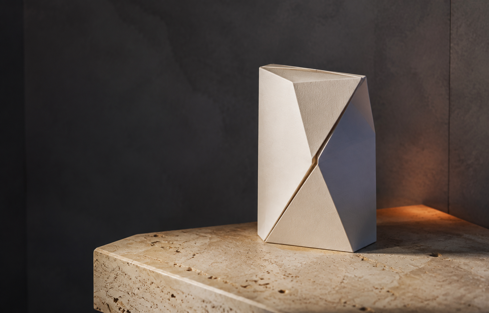 Folded premium paper package on a travertine stone plinth